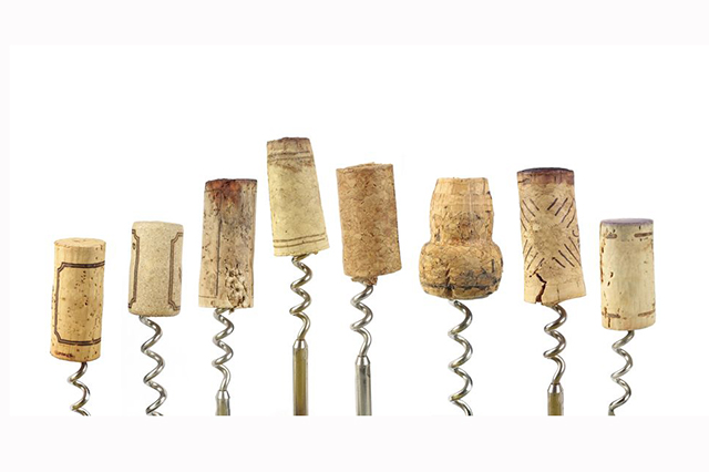 Image of  corkscrews in a row with corks on top of various size and shape